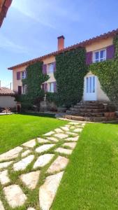 a house with a stone path in front of a yard at Casa Rural Tozolosolobos in Otero de Bodas