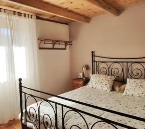 a bedroom with a black bed and a window at Casa Rural Tozolosolobos in Otero de Bodas
