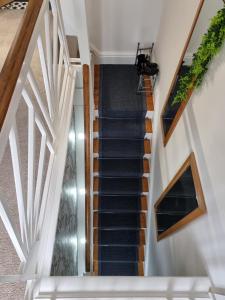 una escalera en una casa con paredes blancas y madera en The View Sandbach en Sandbach