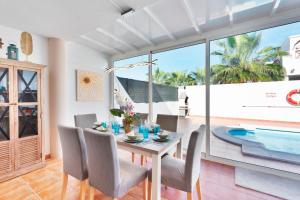 een eetkamer met een tafel en stoelen en een zwembad bij VILLA RENATO in Playa Blanca