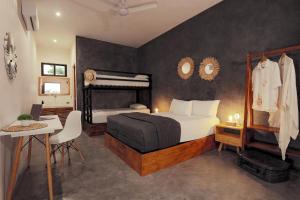 a bedroom with a bed and a desk and a bed at Che Bacalar Hostel & Bar Adults Only in Bacalar