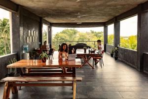 um grupo de pessoas sentadas em mesas num pátio em Che Bacalar Hostel & Bar Adults Only em Bacalar