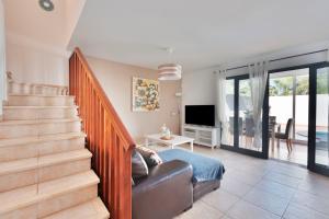 een woonkamer met een trap, een bank en een televisie bij VILLA RENATO in Playa Blanca