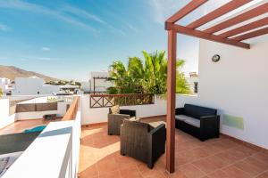 een balkon met stoelen en tafels op een gebouw bij VILLA RENATO in Playa Blanca