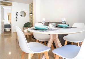 a dining room with a white table and chairs at CALMA Apartments in Benidorm