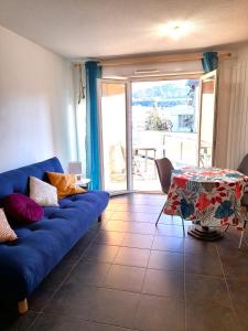 a living room with a blue couch and a table at Marguerite-Gap Centre in Gap