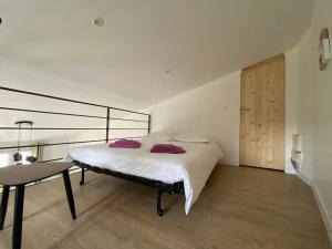 a bedroom with a large bed and a table at Gîte Le Tramontane Meublé de tourisme 4 étoiles Le Moulin de Prédelles in Reillanne