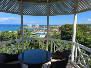 a balcony with a table and chairs and the ocean at Kris’o Super Studio in Ocho Rios