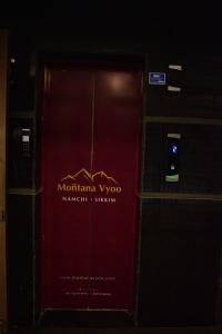 a red door with a sign on it at HOTEL MONTANA VYOO in Namchi