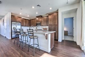 a kitchen with wooden cabinets and a counter with bar stools at Bright Sacramento Home about 9 Mi to Dtwn in Sacramento