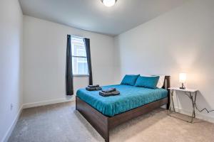 a bedroom with a bed with blue sheets and a window at Bright Sacramento Home about 9 Mi to Dtwn in Sacramento