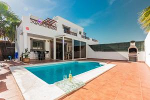 een zwembad voor een huis bij VILLA RENATO in Playa Blanca