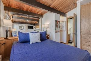 um quarto com uma cama azul e um tecto de madeira em Laurelwood Condominiums 113 em Snowmass Village