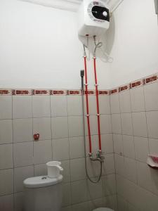 a bathroom with a shower with a toilet and a camera at D5 Homestay Syariah Sumampir Purwokerto in Purwokerto