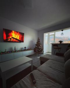 uma sala de estar com lareira e uma árvore de Natal em Mountain View em Sinaia