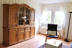 un gran armario de madera en una sala de estar con una silla en Ferienwohnung Paulita en Soltau
