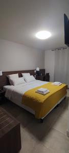 a bedroom with a large bed with a yellow blanket at SQUARE HOTEL in Nîmes