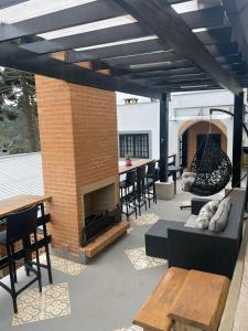 Un patio con chimenea y una mesa y sillas. en Cabana Toscana, en Campos do Jordão