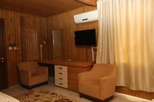 a bedroom with a desk and a tv and two chairs at Nemrut Kommagene Hotel in Kahta