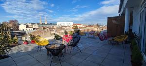 a patio with chairs and tables on a balcony at SQUARE HOTEL in Nîmes