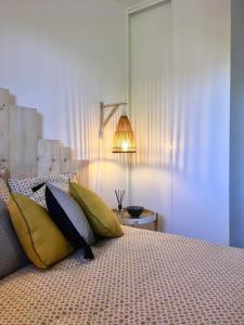 sypialnia z łóżkiem z żółtymi i niebieskimi poduszkami w obiekcie Cabourg T2 tout neuf Accès direct mer Grand balcon w mieście Cabourg