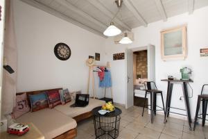 ein Wohnzimmer mit einem Sofa und einer Uhr an der Wand in der Unterkunft Mykonos Amazing Apartments 2 in Mykonos Stadt