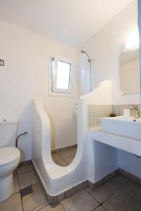 a white bathroom with a sink and a toilet at Mykonos Amazing Apartments 2 in Mikonos