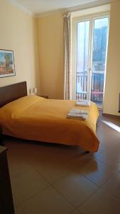 a bedroom with a large yellow bed with a large window at B&B Vivaldi in Palermo