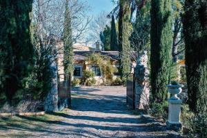 eine Auffahrt zu einem Haus mit einem Tor und Bäumen in der Unterkunft Villa de lujo a 50km de Madrid in Pezuela de las Torres