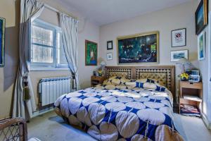 a bedroom with a bed with a blue and white comforter at Villa de lujo a 50km de Madrid in Pezuela de las Torres