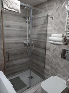 a bathroom with a shower with a toilet and towels at Kurzacka Chata in Szklarska Poręba