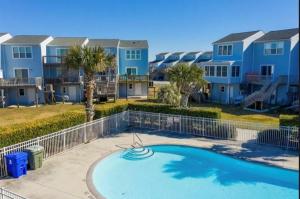 a swimming pool in front of some apartments at The Salted Rim in North Topsail Beach