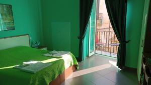 a green bedroom with a bed and a large window at B&B Vivaldi in Palermo