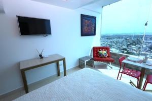 een slaapkamer met een bed, een bureau en een televisie bij Mejor que un Hotel in Salinas