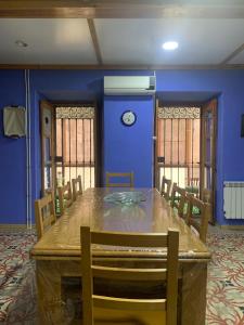 un comedor con una gran mesa de madera y paredes azules en Casa Rural Tía Paulina, en Calmarza