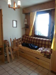 - un salon avec un canapé et une fenêtre dans l'établissement Les Espaces Lichens 06, à Samoëns