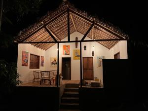 a small white house with a table and chairs at Canopee Lodge in Nosy Komba