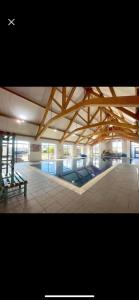 a large building with a pool and a wooden ceiling at Park Dean Morcambe in Bare