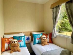two beds with stuffed animals on them in a bedroom at Park Dean Morcambe in Bare