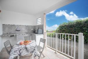 a table and chairs on a balcony with a kitchen at Studio Le Lotus Doré in Sainte-Marie