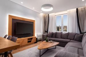 sala de estar con sofá y TV de pantalla plana en Acropolis Exclusive Residences, en Atenas