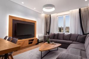 a living room with a couch and a flat screen tv at Acropolis Exclusive Residence in Athens