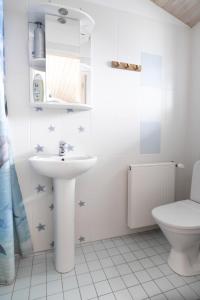 bagno bianco con lavandino e servizi igienici di Roograhu guesthouse&resto a Hiiessaare