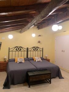 Casa Rural Tía Paulina في Calmarza: غرفة نوم بسرير كبير مع اللوح الخشبي