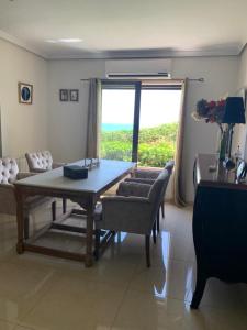 a living room with a table and chairs and a window at Camino del Faro LALBIR Alicante in Albir