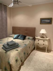 a bedroom with a bed and a table with a lamp at Camino del Faro LALBIR Alicante in Albir +25 photos