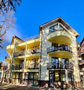 um edifício de apartamentos com varandas e um céu azul em Vila Condor em Poiana Brasov