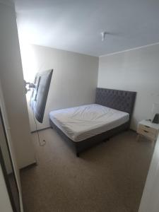 a bedroom with a bed and a television in it at Departamento por día 3 dormitorios y 2 baños in Arica