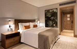 1 dormitorio con 1 cama blanca grande y cabecero de madera en L'Hotel PortoBay São Paulo, en São Paulo