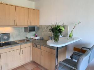 a kitchen with a table with a vase of flowers on it at Luna-Wohnung-12 in Sankt Peter-Ording